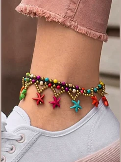 Chaîne de cheville fantaisie avec pendentifs étoile de mer colorés, qui apporte instantanément une ambiance de plage estivale à votre look