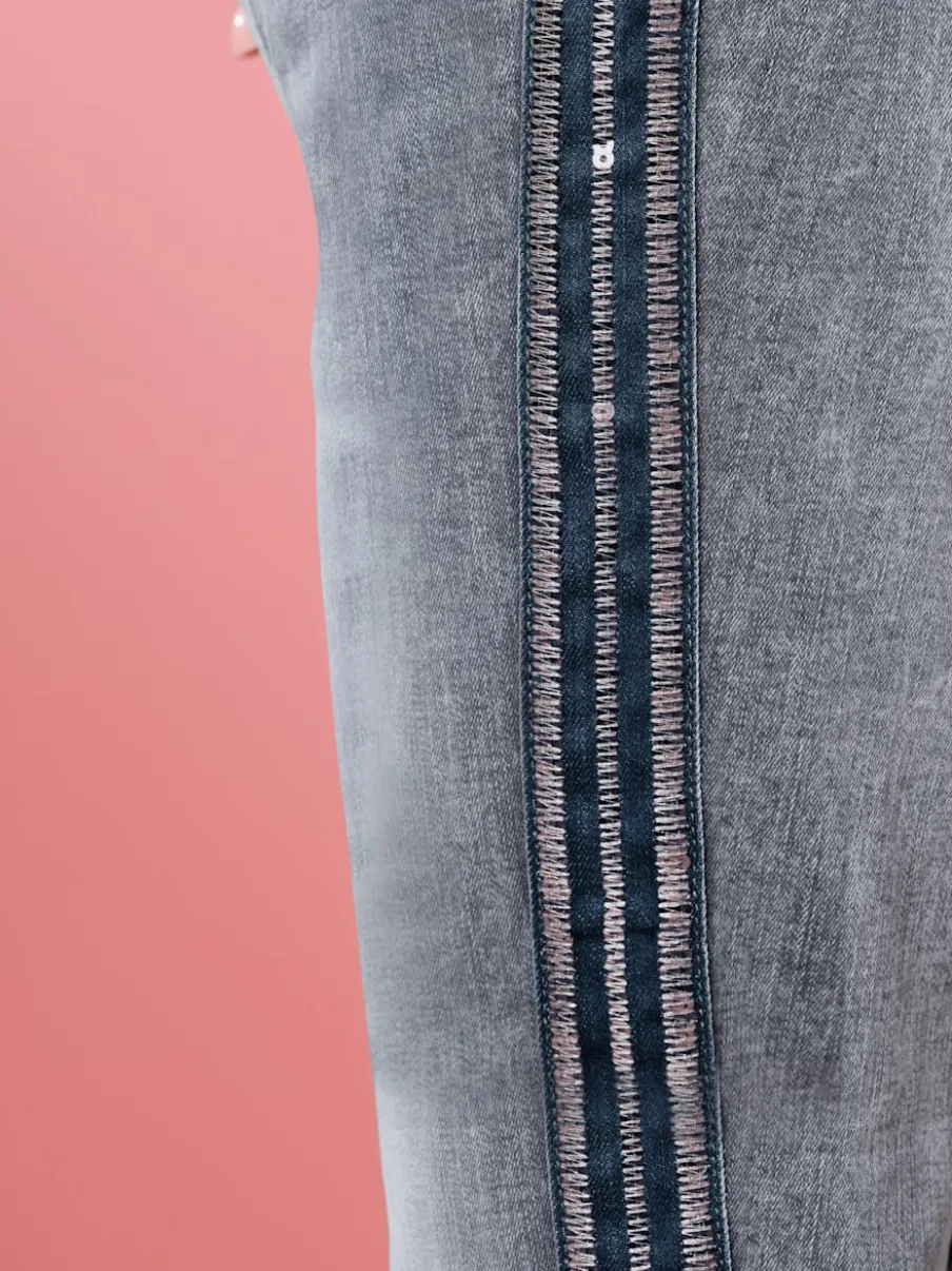 Jean 7/8 avec rayures décoratives et paillettes.