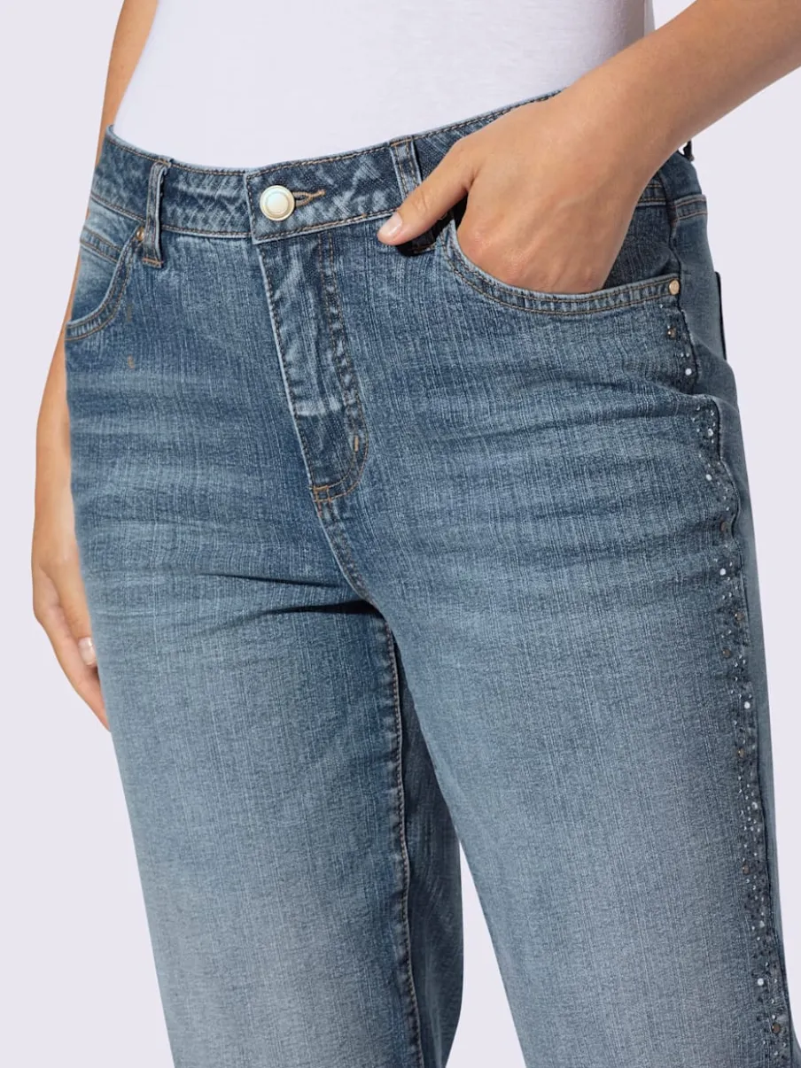 Jean denim doux avec bijoux fantaisie et revers.