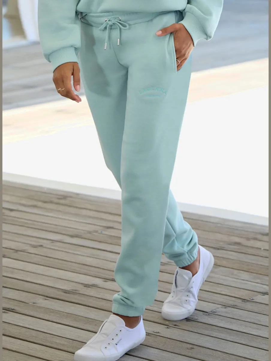 Pantalon sweat avec logo brodé et poches latérales fendues