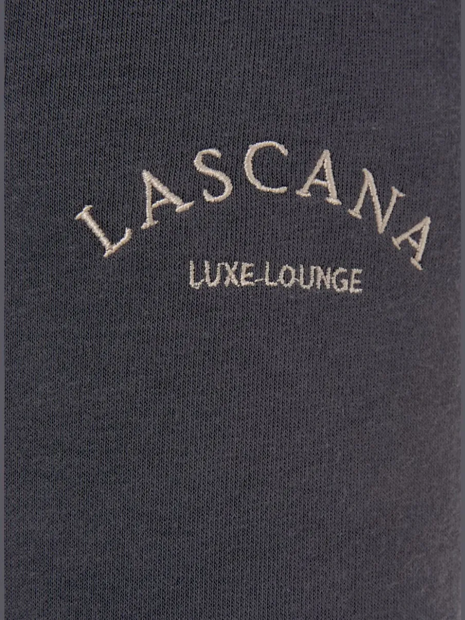 Pantalon sweat avec logo brodé et poches latérales fendues