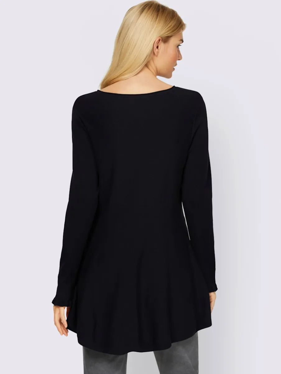 Pull long légèrement évasé avec bords roulés et volants