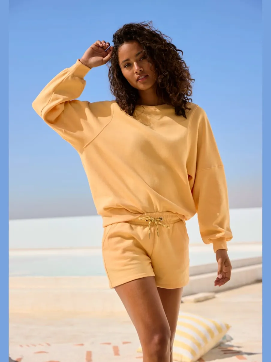 Short en matière sweat avec ruban à coulisse et poches fendues